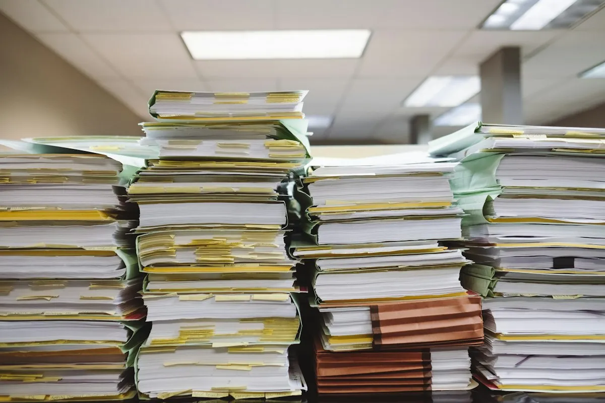 Stacks of real working documents and folders awaiting review